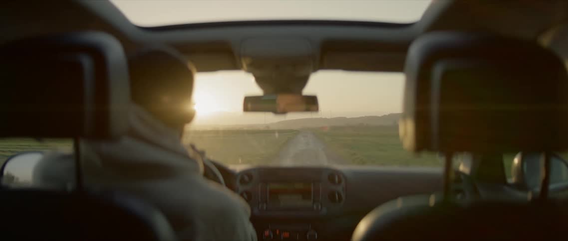 A man driving a vehicle down a road through the countryside