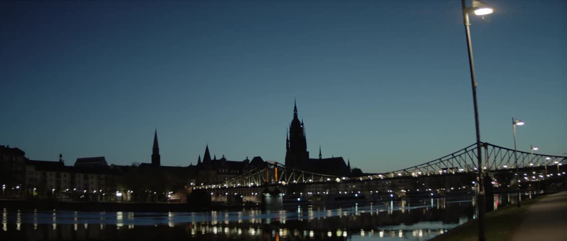 A bridge over a lake with the skyline in the distance