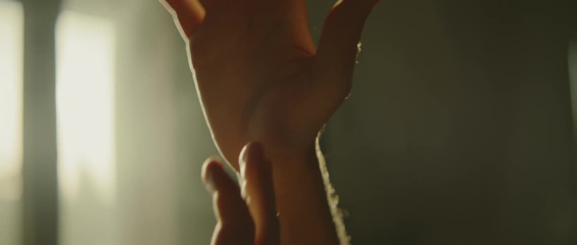 A persons hands moving with sunlight in the background