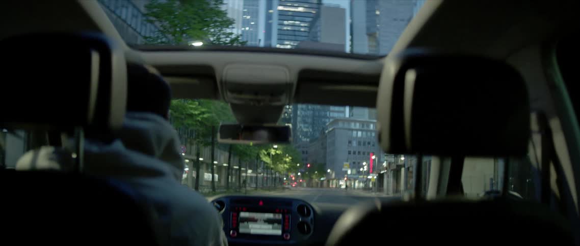 A person is driving a car through a downtown city
