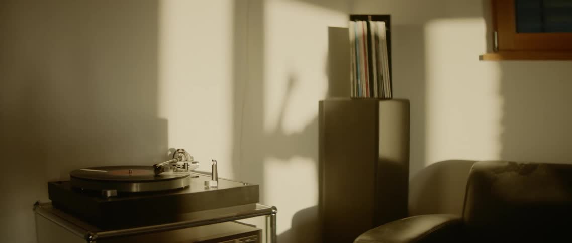 A shadow of a person moving around in their home casts on the wall