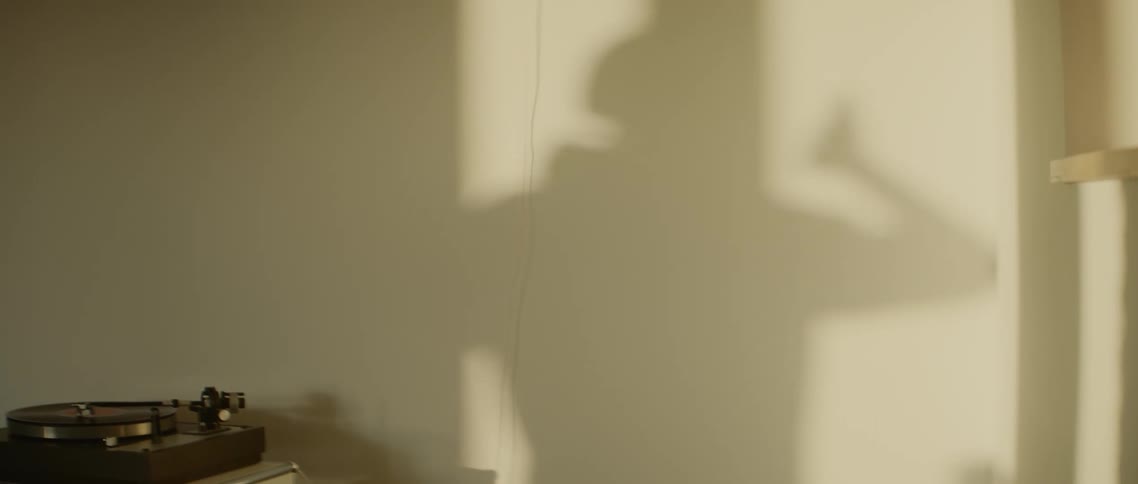 A persons shadow dances on the wall