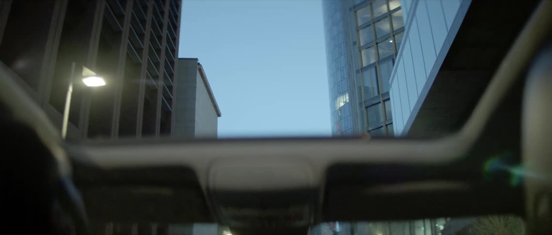 A man is driving a car through a downtown city