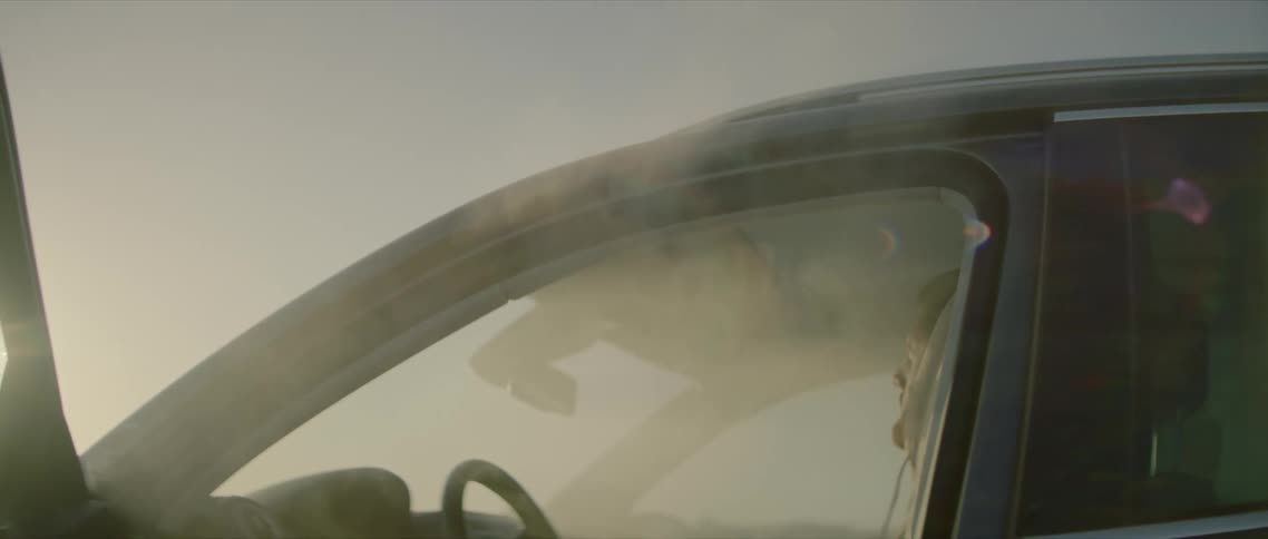 An unconscious man sitting in a car filled with smoke