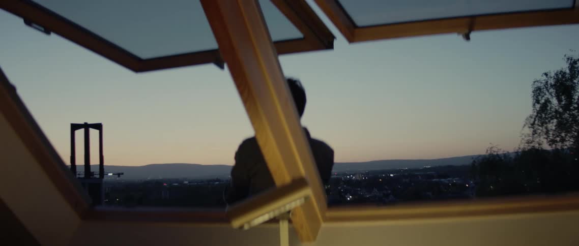A man watches the sunset from the hill top