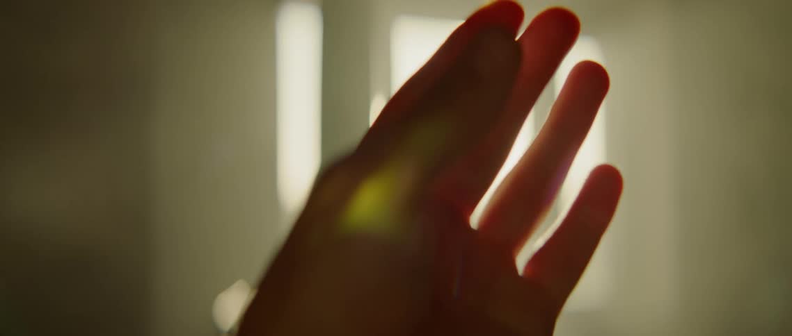 A person is moving their hand and theres a glare from the window