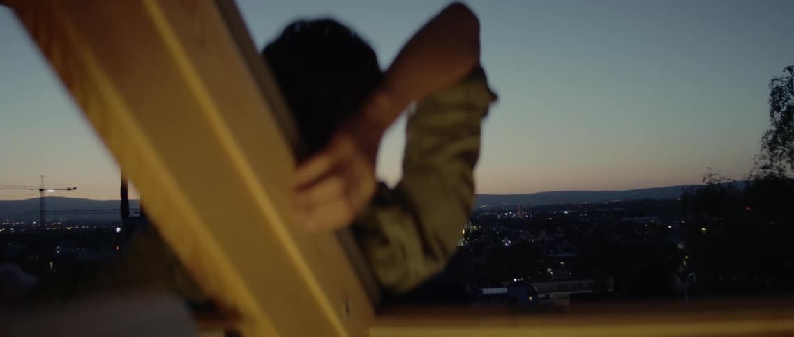 A man is on a hill watching the sunset