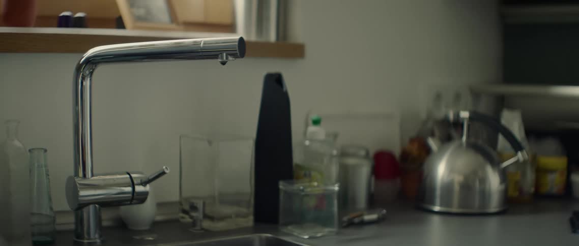 Water drips from the tap into the sink