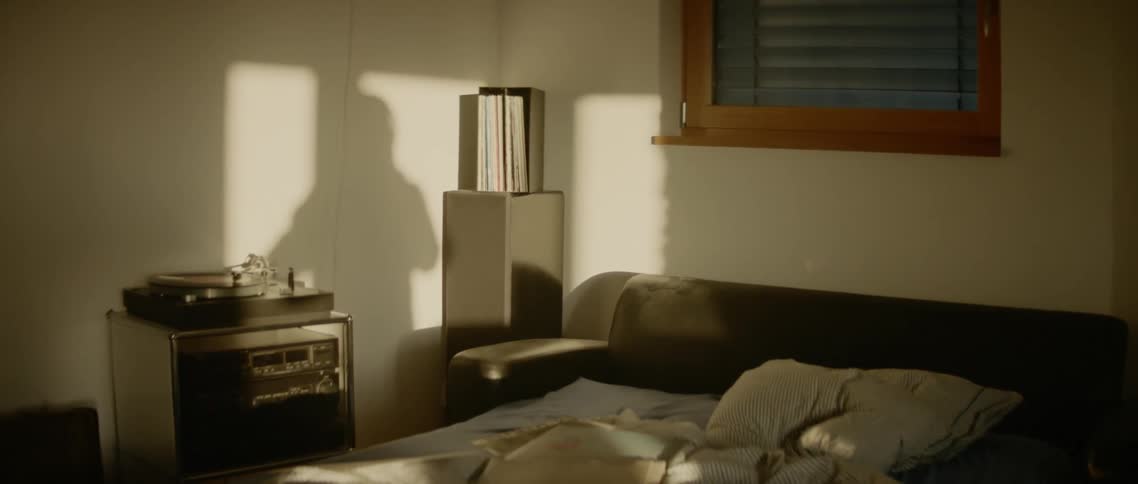 The shadow of the man is reflected in the wall in a room