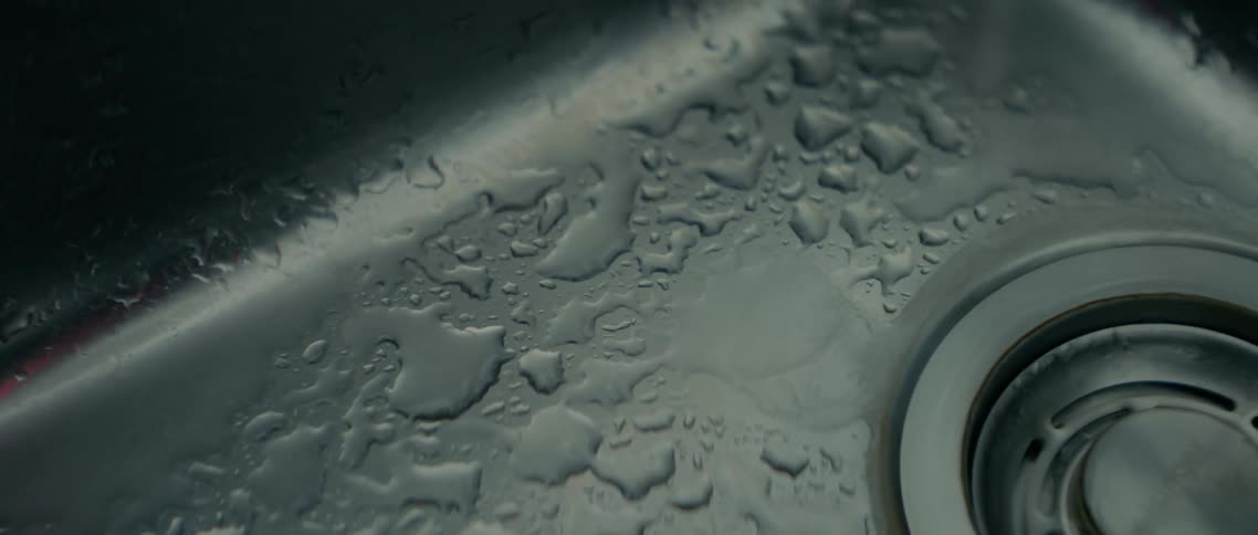 Water drips from the tap into the sink