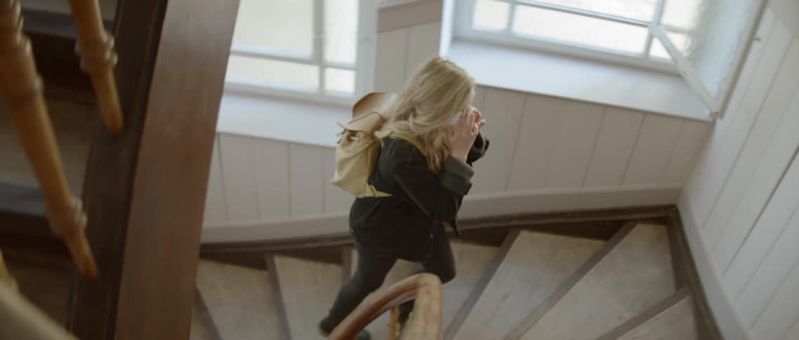 A woman slowly climbs the stairwell