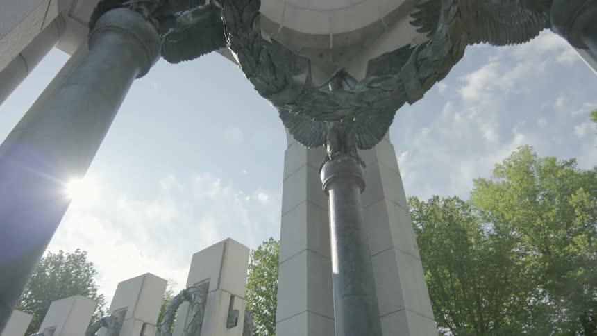People jog in the park past the world war ii memorial where four eagles hold up a wreath