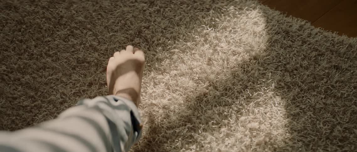 A person is extending their leg and moving their toes while indoors during the day