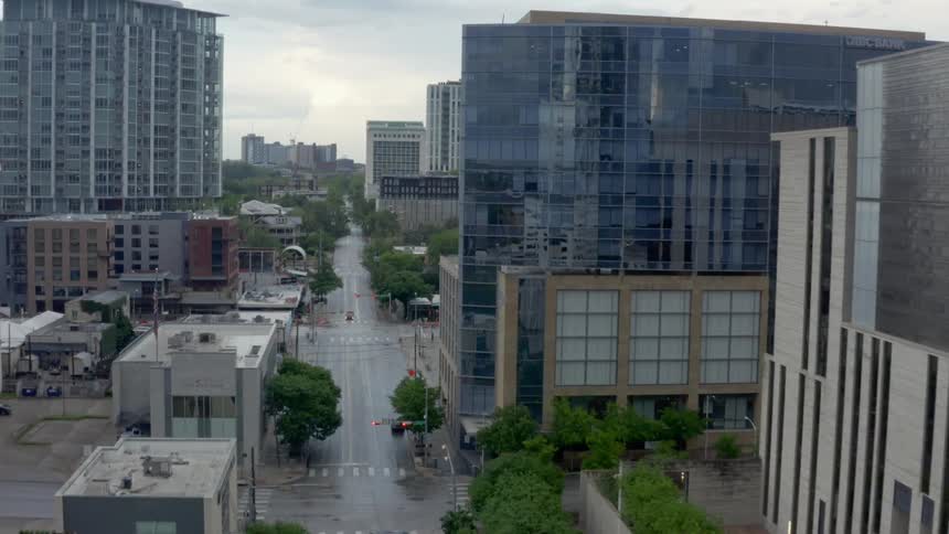 A city street is empty but surrounded by tall buildings