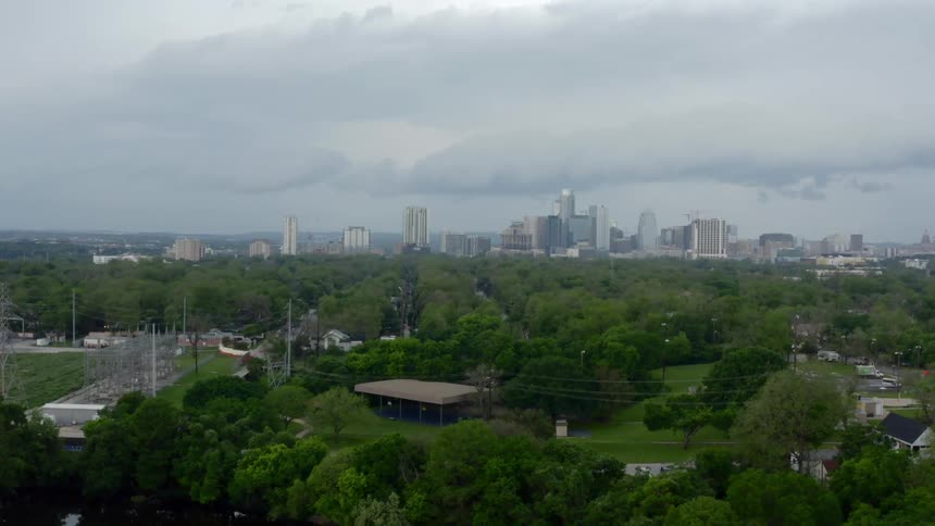 A pond with trees with the city skyline in the background