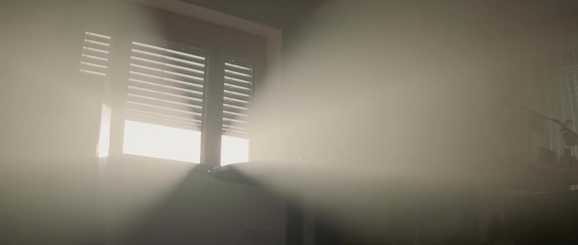 Venetian blinds slats are being opened slowly and the sun streams through the window