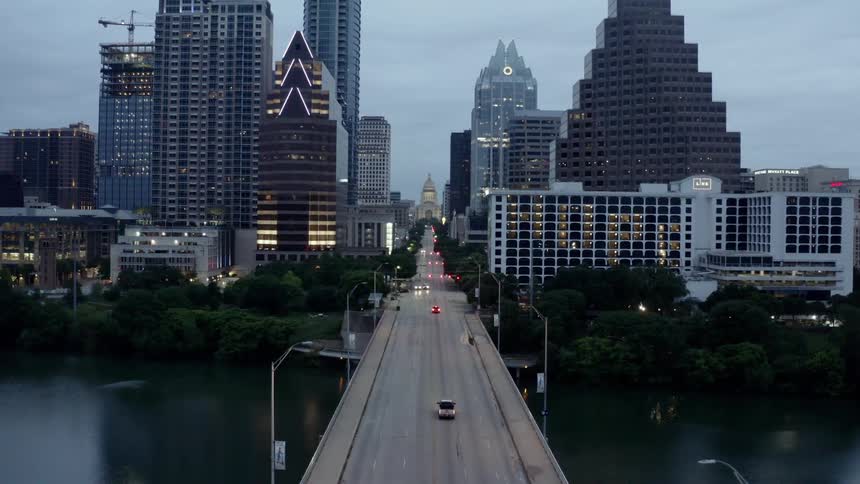 Vehicles travel over the bridge towards the city