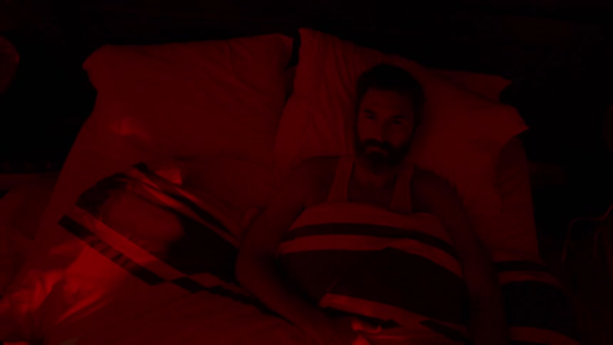 A man is lying in his bed at night