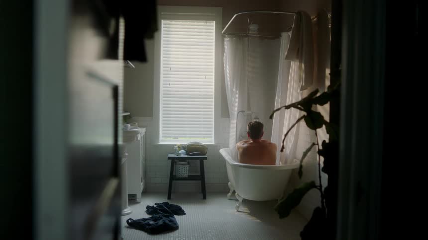 A man sits in his bathtub bathing