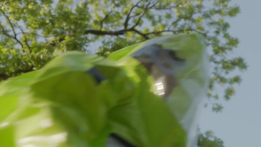 Person in personal protective suit walks under tree