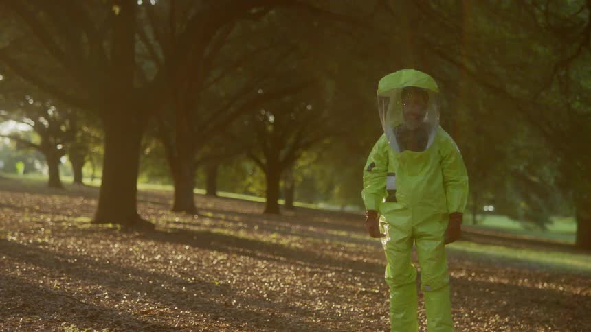 A man standing in the forest with a hazmat suit