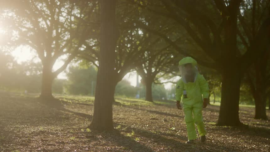 A man in a hazmat suit looks around as he walks