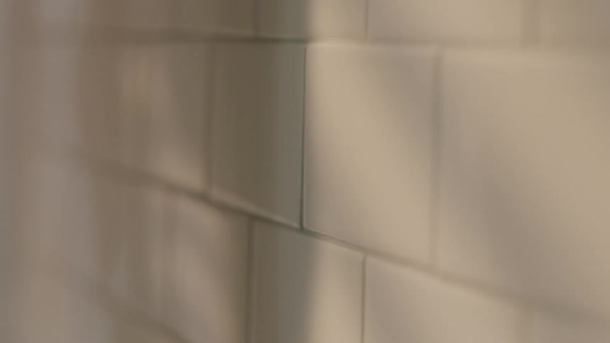 White tiles with a shadow moving on it