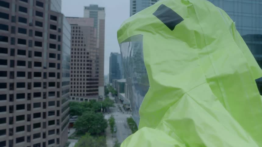 A man in protective gear looks out a the city