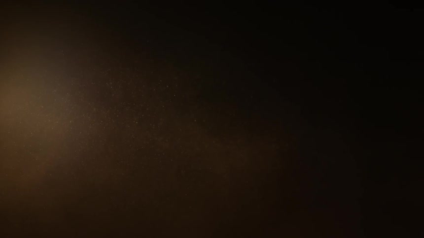 Particles float in front of a dim light source