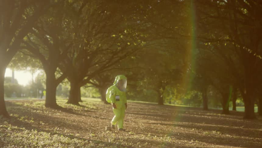 A man in protective wear walks and looks around him