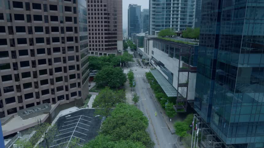 A person in protective gear walks down an empty downtown street