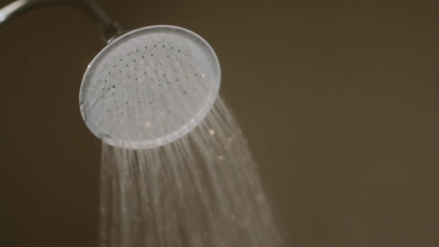 A shower with water is running in a bathroom