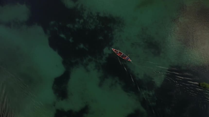 Aerial view of a rowboat floating down a river