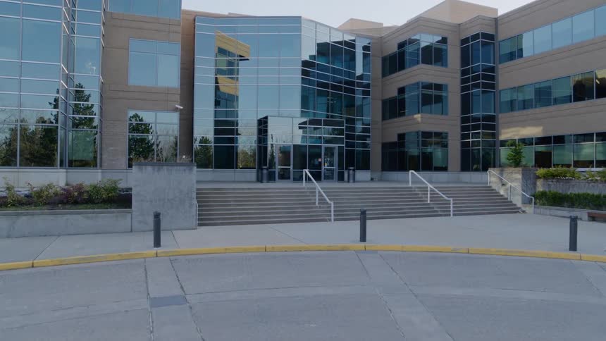 A modern office building entrance with reflective glass windows
