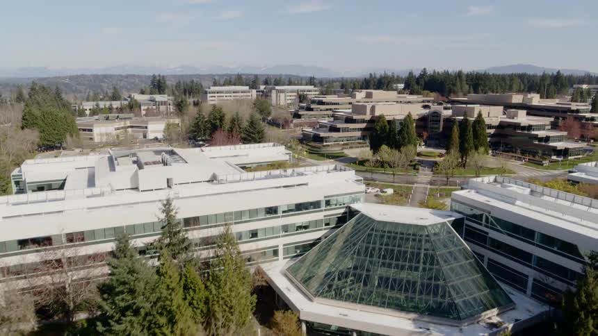 Ascent reveal of an office park surrounded by trees