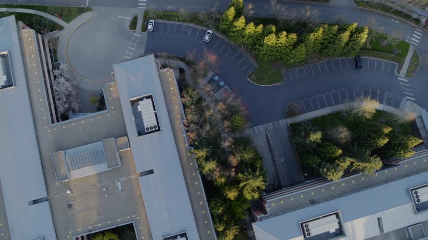 Birds eye view of corporate campus buildings and cars parked in the parking lot