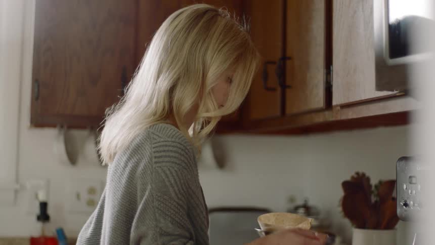 Woman scoops out coffee in order to prepare coffee in kitchen