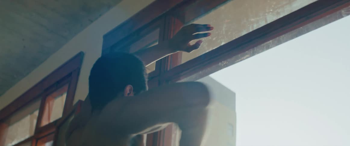 A man is dancing by a window indoors