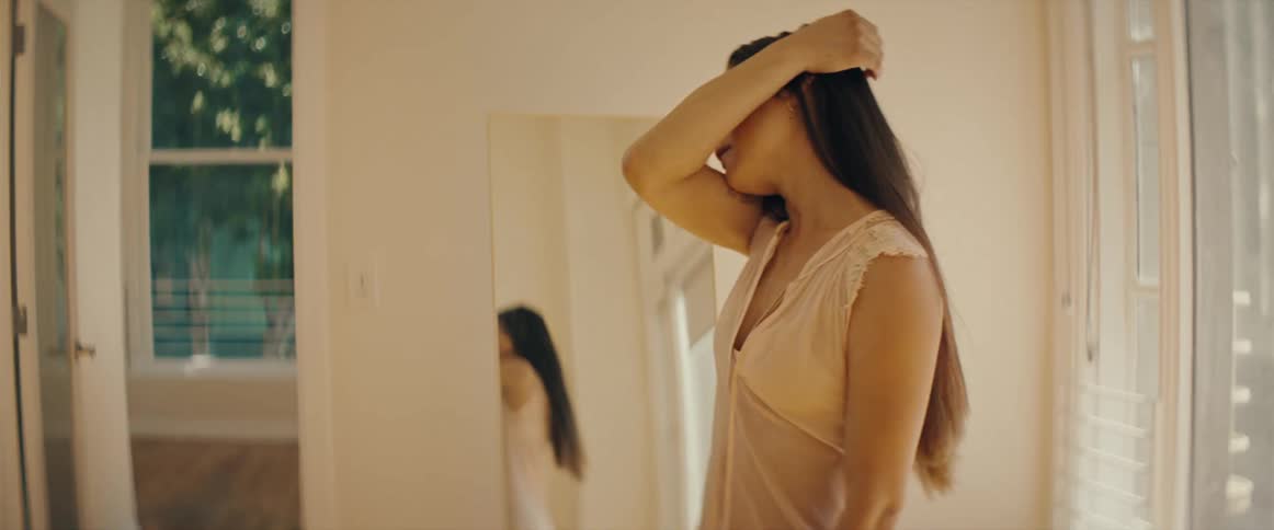 A woman dances in front of the mirror