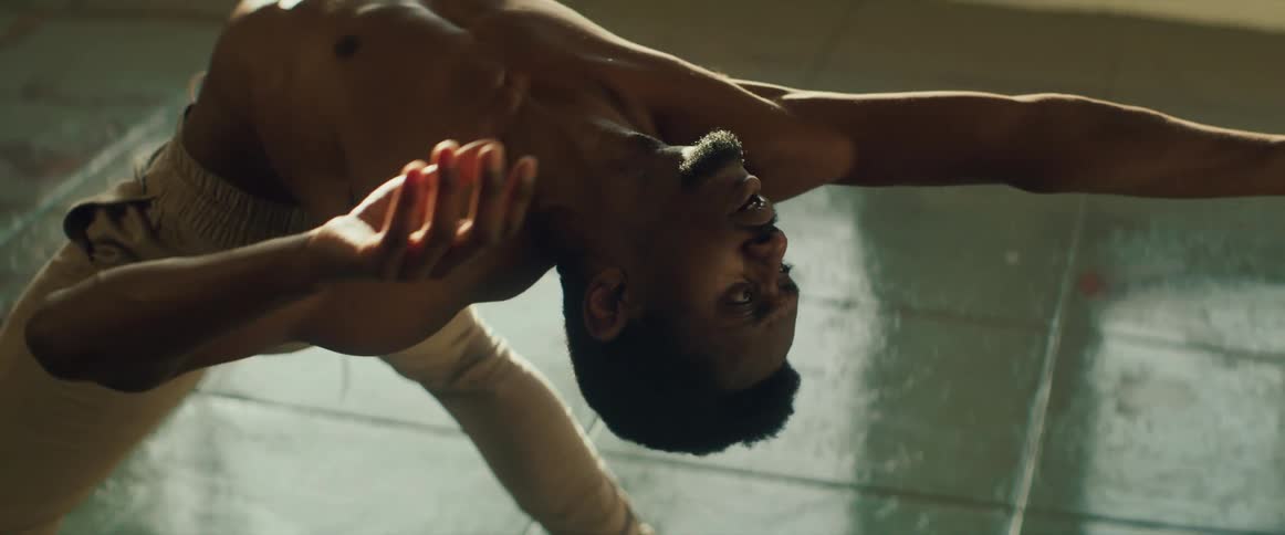 Dancer stretches and poses on tiled floor