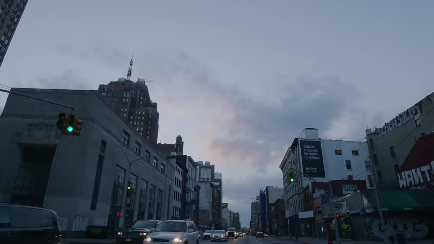 A city street with vehicles buildings and traffic lights