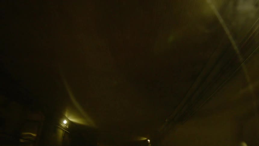 Lights placed near ceiling dimly light corridor