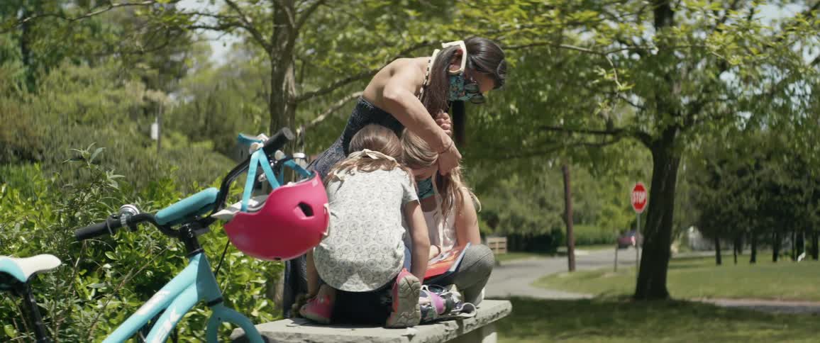 A woman tightens the mask of her child
