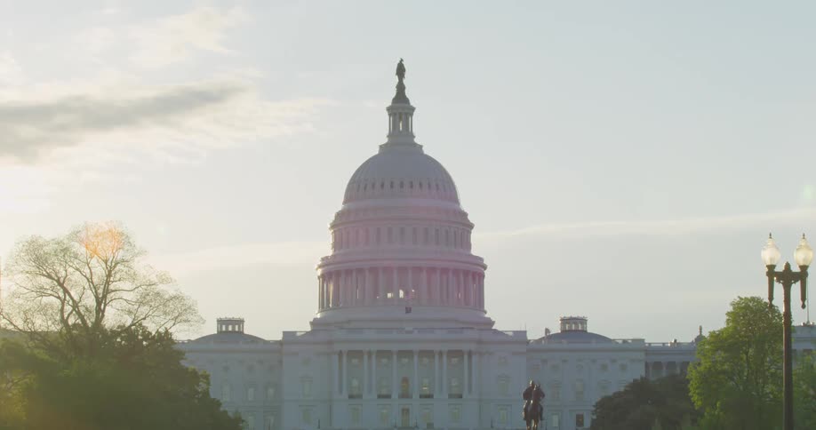 The sun rises over a domed capitol building