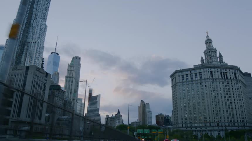 A city street with vehicles buildings and skyscrapers