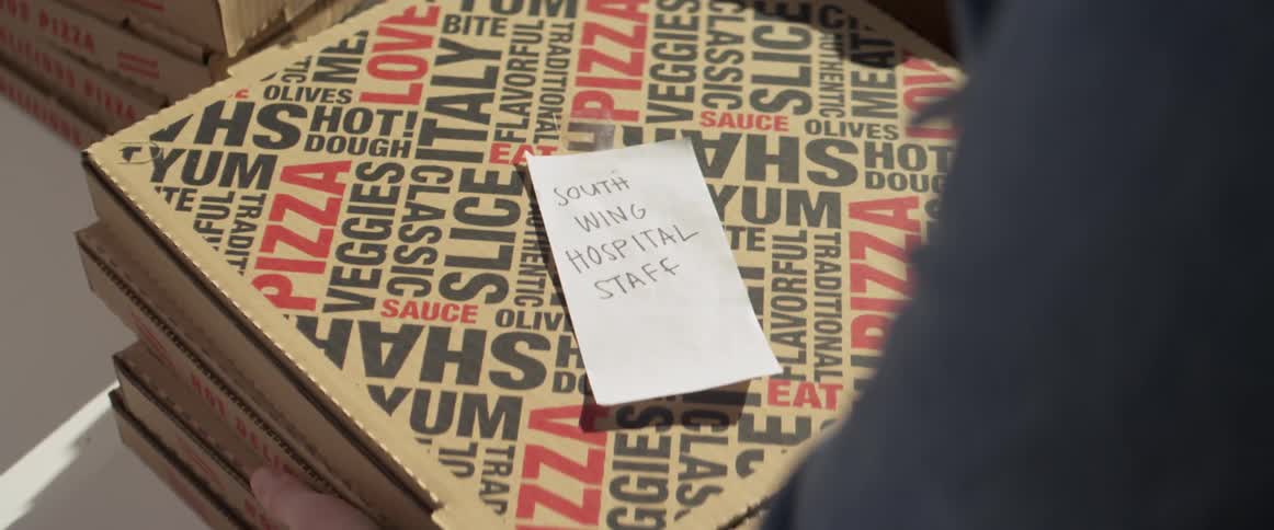 Boxes of pizza are prepared for delivery to a hospital