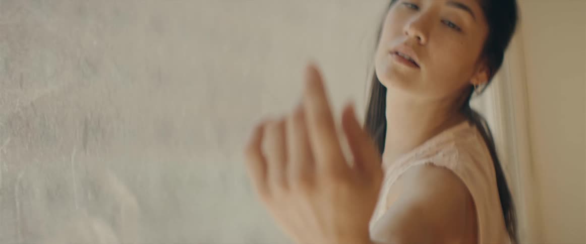 A woman dances against a window in her downtown apartment