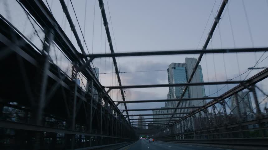 Cars travel along highway near downtown city covered with wire and metal framework