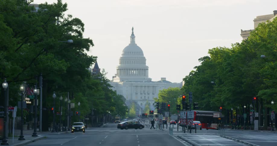 The united states capitol and vehicles driving on the highway and turning at the intersection