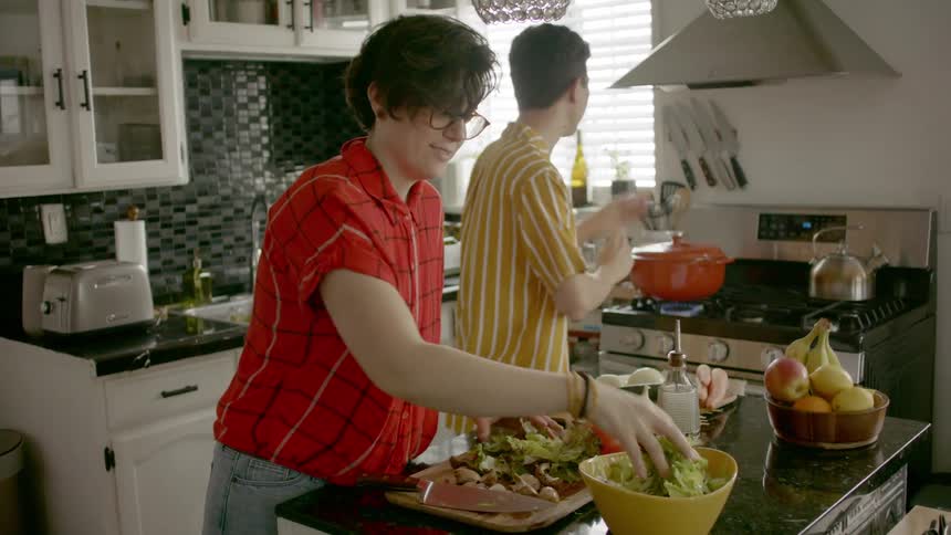 Couple hanging out preparing a meal in their kitchen